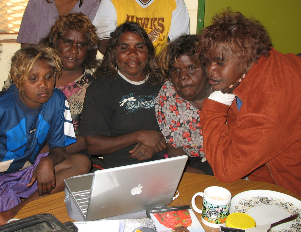 Marlene Nampitjinpa (center) with some relatives watching some of Dunlop's footage on a laptop at Kintore, 2006.